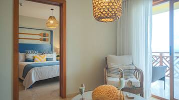 Habitación de hotel con cama, una silla, una mesa y un balcón con vistas.