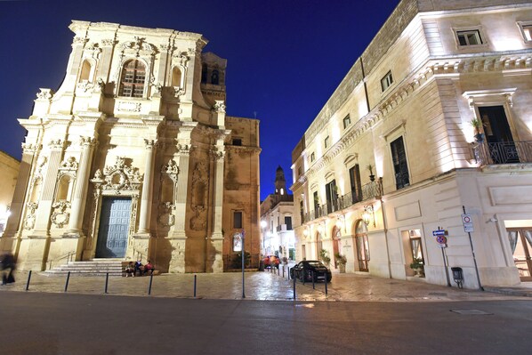A historic building with ornate architecture, a bell tower, and a paved street in the foreground. - SANTA CHIARA Suite Hotel & Spa - Lecce (Lecce)