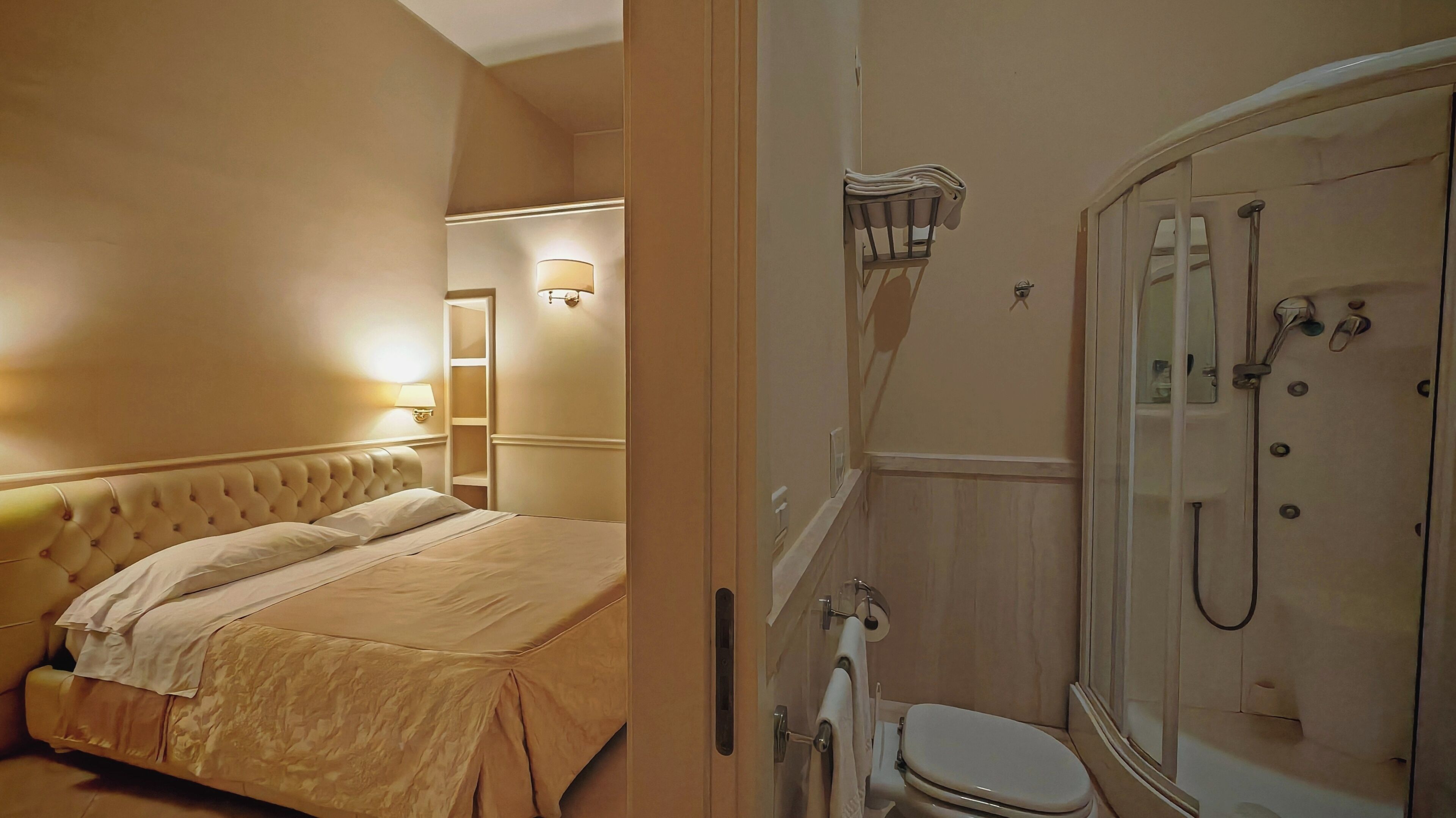 Ein Hotelzimmer mit einem Bett, einem Badezimmer mit Dusche und einem Spiegel.