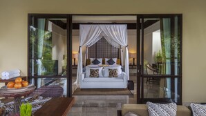 Un dormitorio con cama a dosel, un comedor con mesa y sillas, y vistas al exterior.