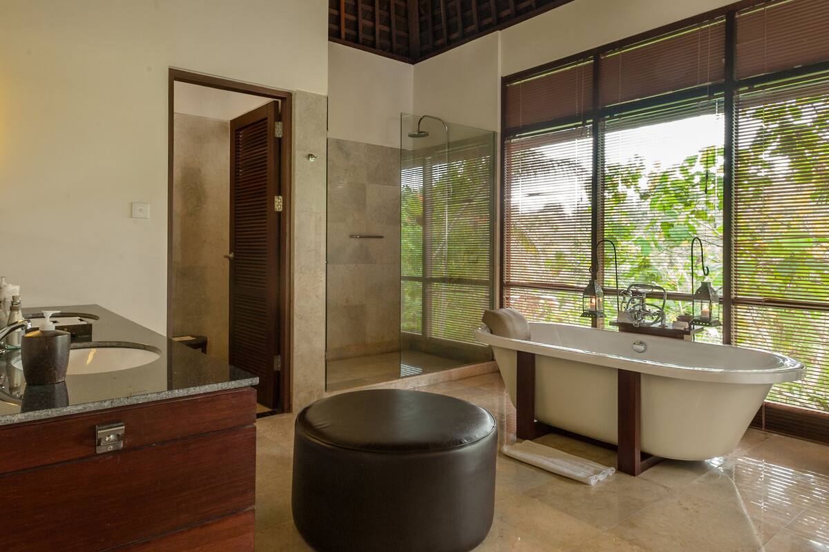 A modern bathroom with a freestanding bathtub, a walk-in shower, and a vanity with a marble countertop.