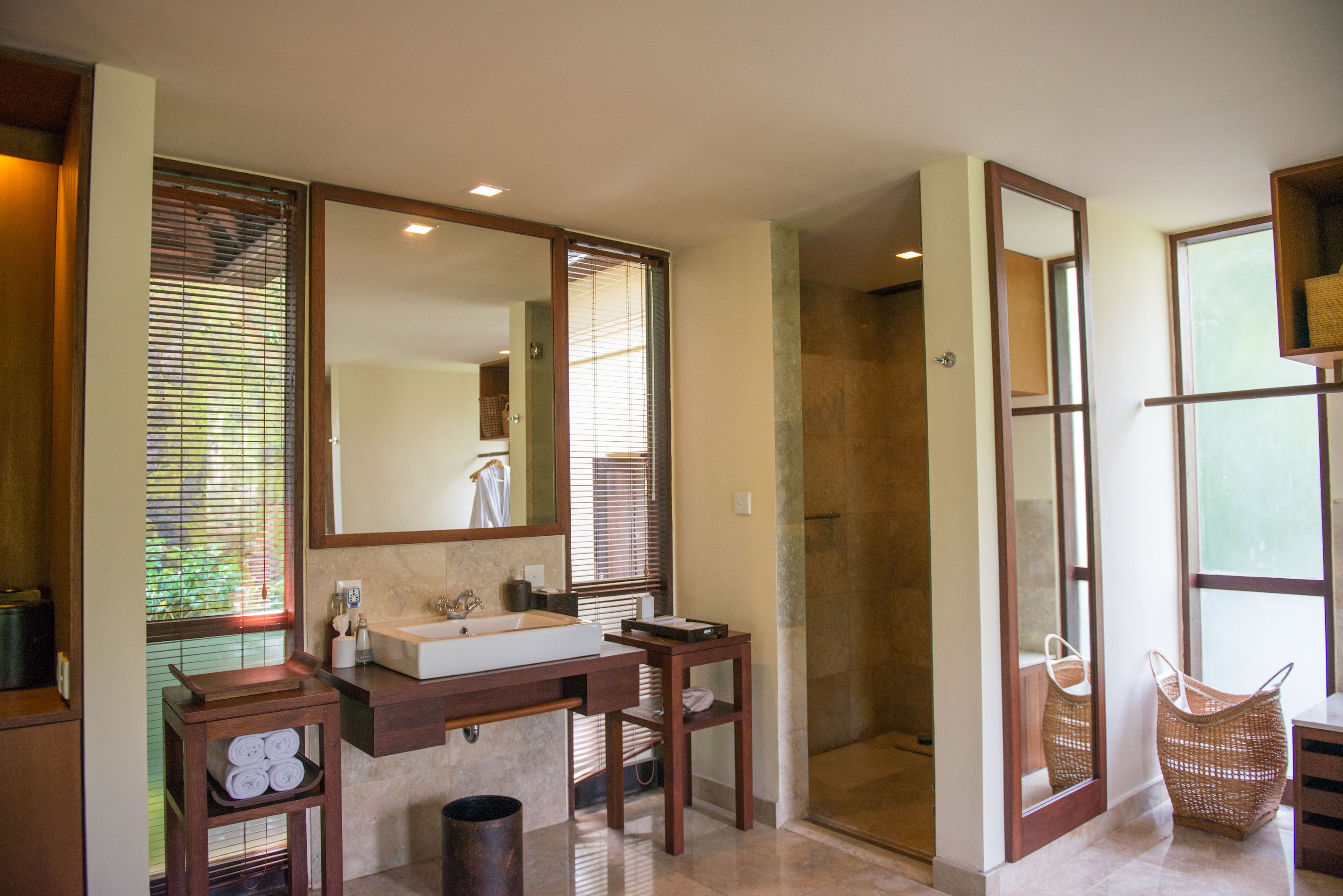 A bathroom with a large mirror, a sink, and a shower.