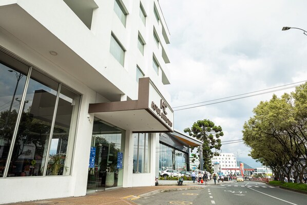 Um hotel moderno com grandes janelas e uma placa indicando ser um hotel.
