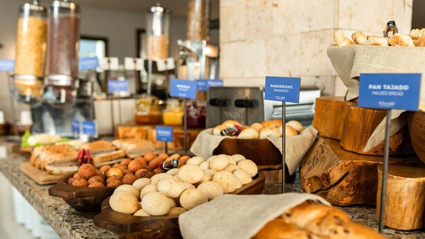 A buffet with various breads and pastries, including a sign for 'Pandedro' and 'Pan Tajo'. - Hotel Carretero (Manizales)