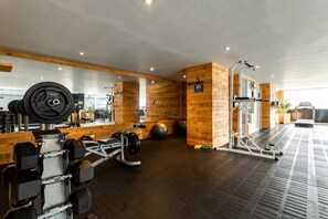 Uma academia com paredes de madeira, equipamentos de exercício e um espelho.