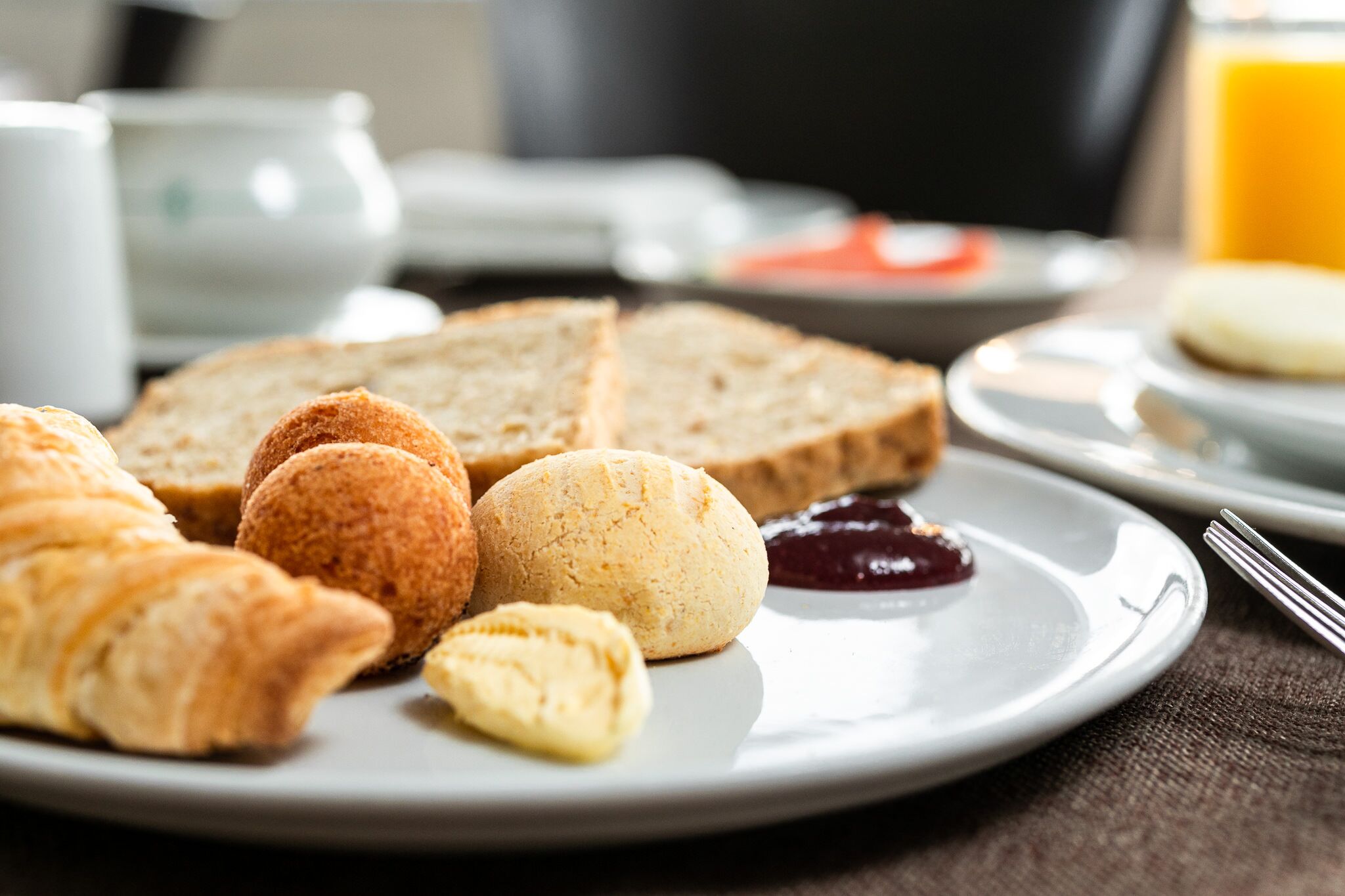 A breakfast plate with croissants, a muffin, and a slice of bread.