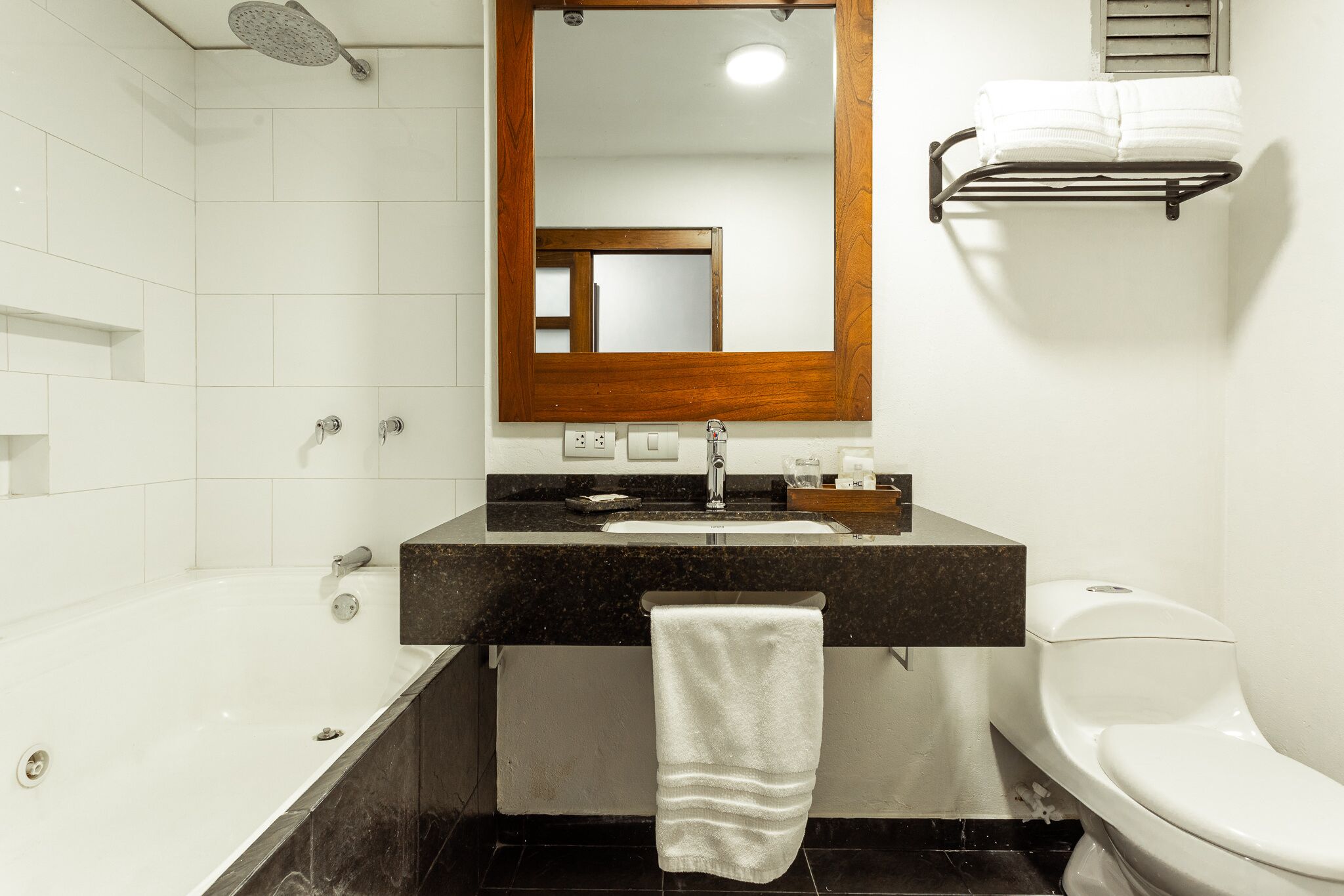 A modern bathroom with a bathtub, sink, and toilet.