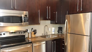 A modern kitchen with stainless steel appliances, including a microwave, oven, and refrigerator.