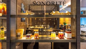 Presentación de Sonorité à table con diversos alimentos y bebidas.