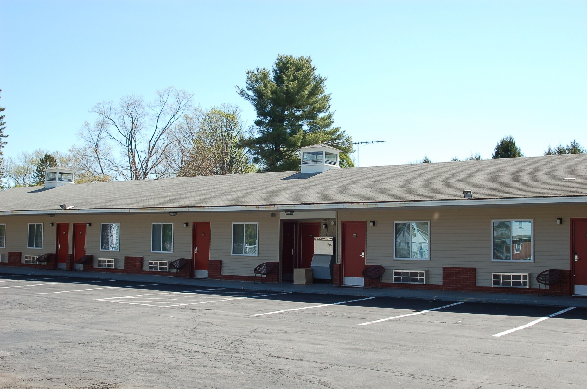 A motel with a row of rooms, each with a door and window.