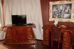 A wooden entertainment center with a flat-screen TV, a small stereo, and a decorative telephone. - Dewani Villa Resort (Kerobokan)