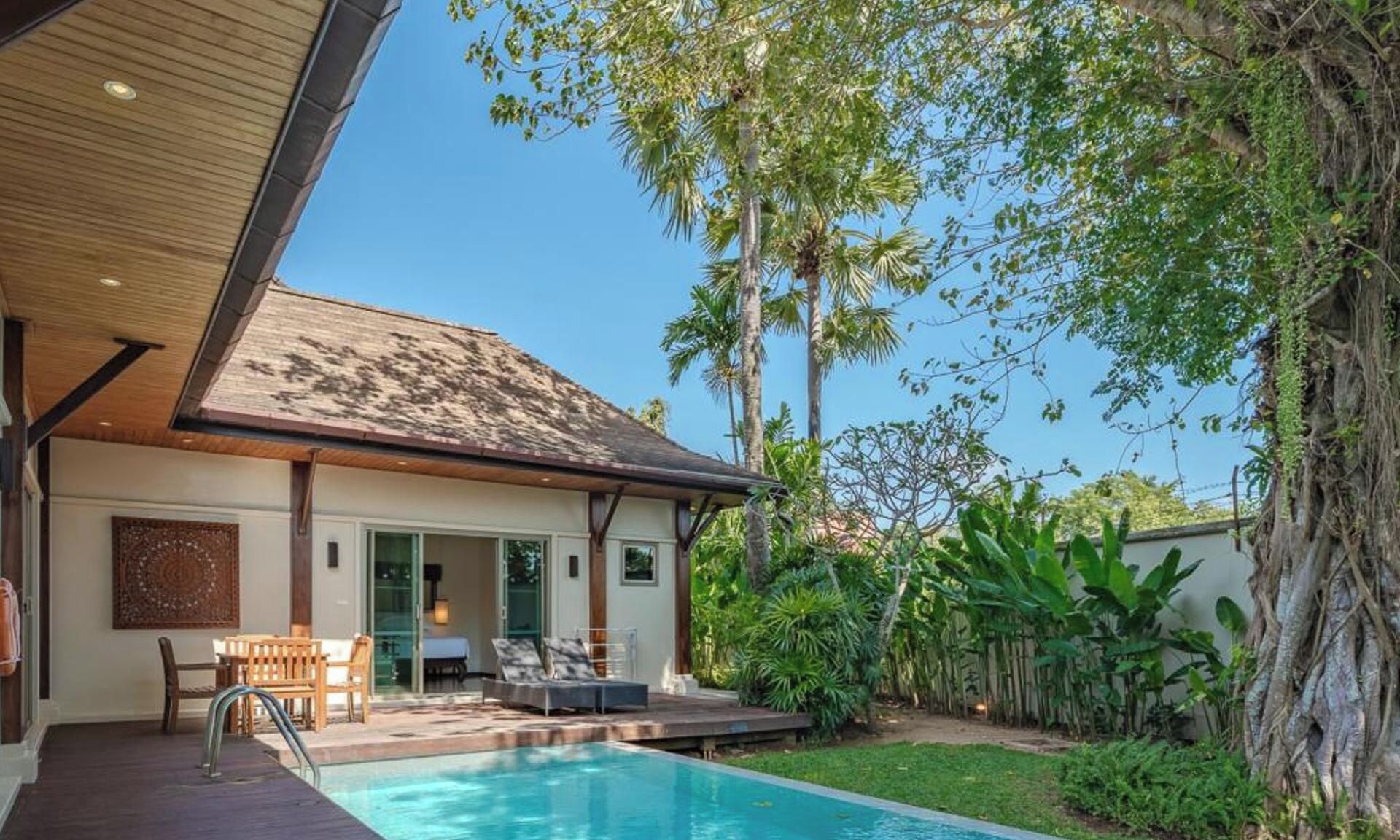 A modern house with a swimming pool, a covered patio, and lush greenery.