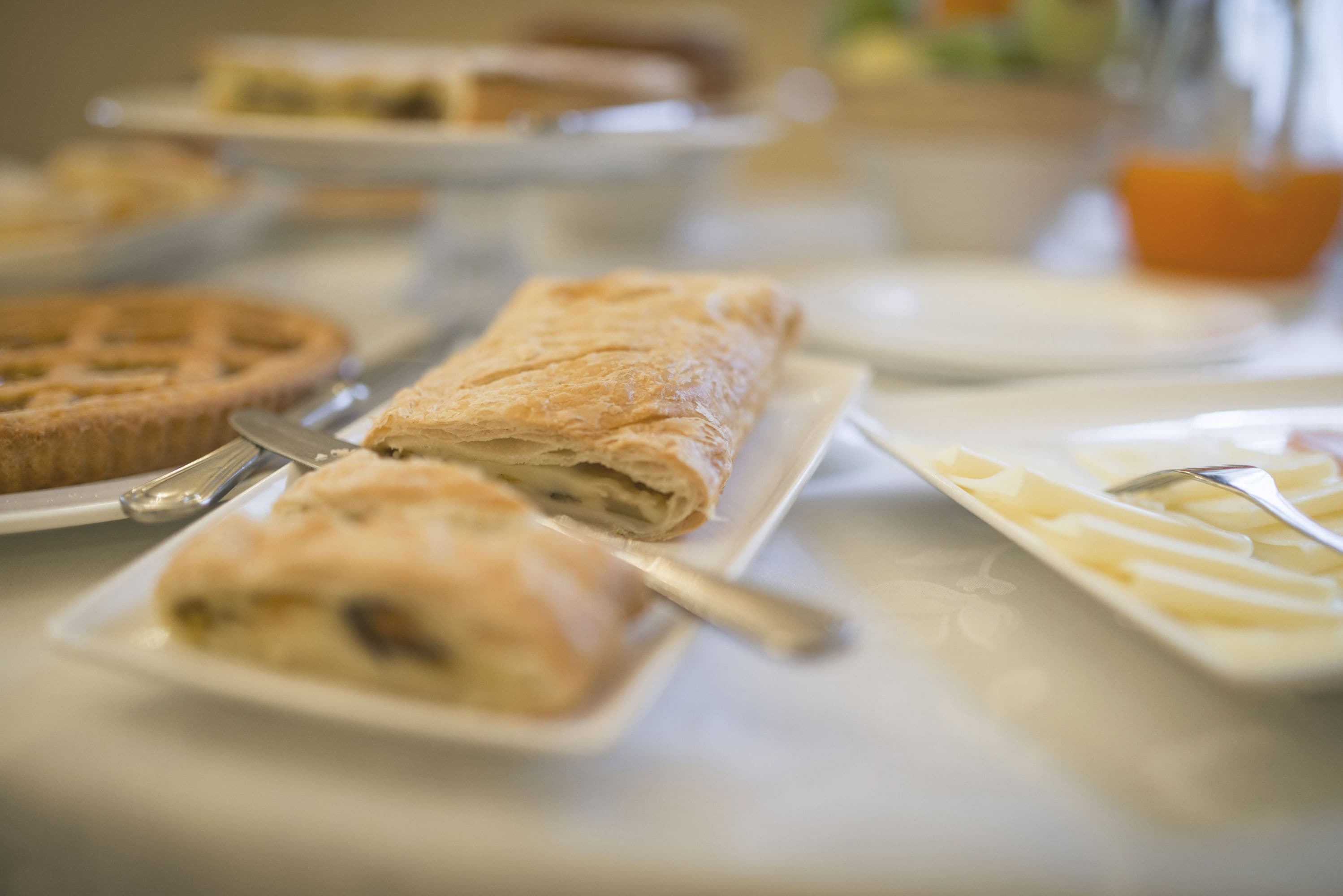Une table de buffet proposant divers plats, notamment des tartes et des pâtisseries.