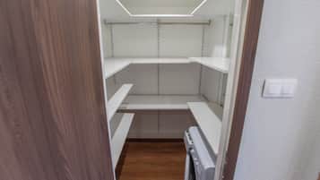 A narrow hallway with wooden flooring, white walls, and a white ceiling with recessed lighting.