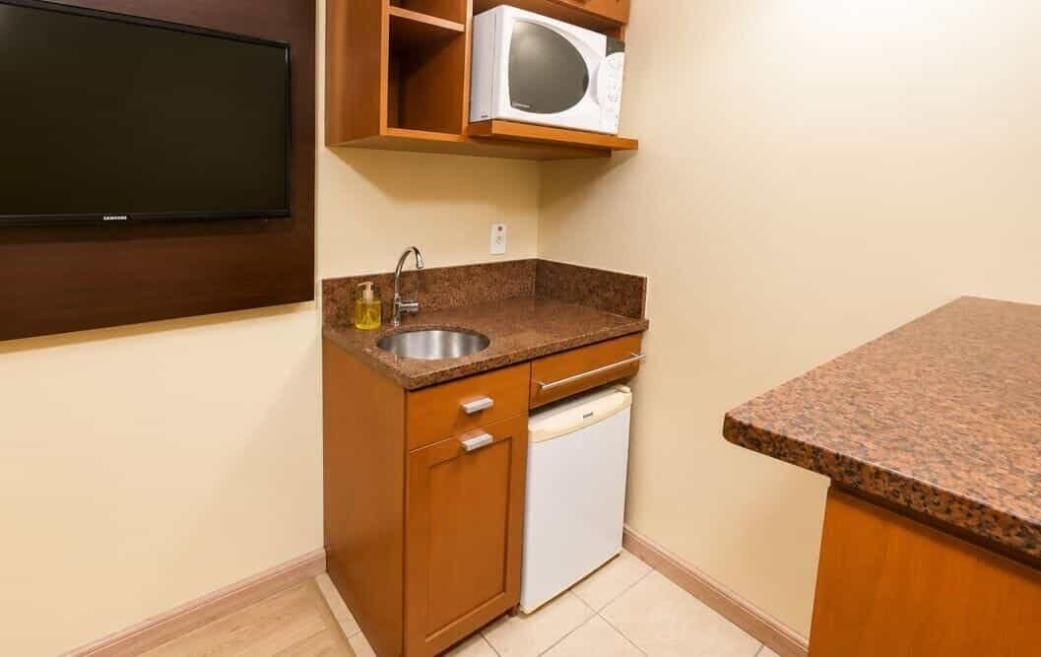 A compact kitchen with a built-in microwave, a sink, and a dishwasher.
