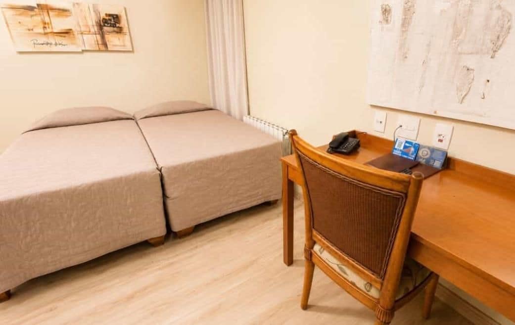 A room with a bed, a desk, and a chair.