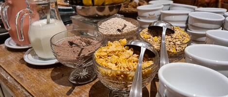 A breakfast buffet with various food items and utensils.
