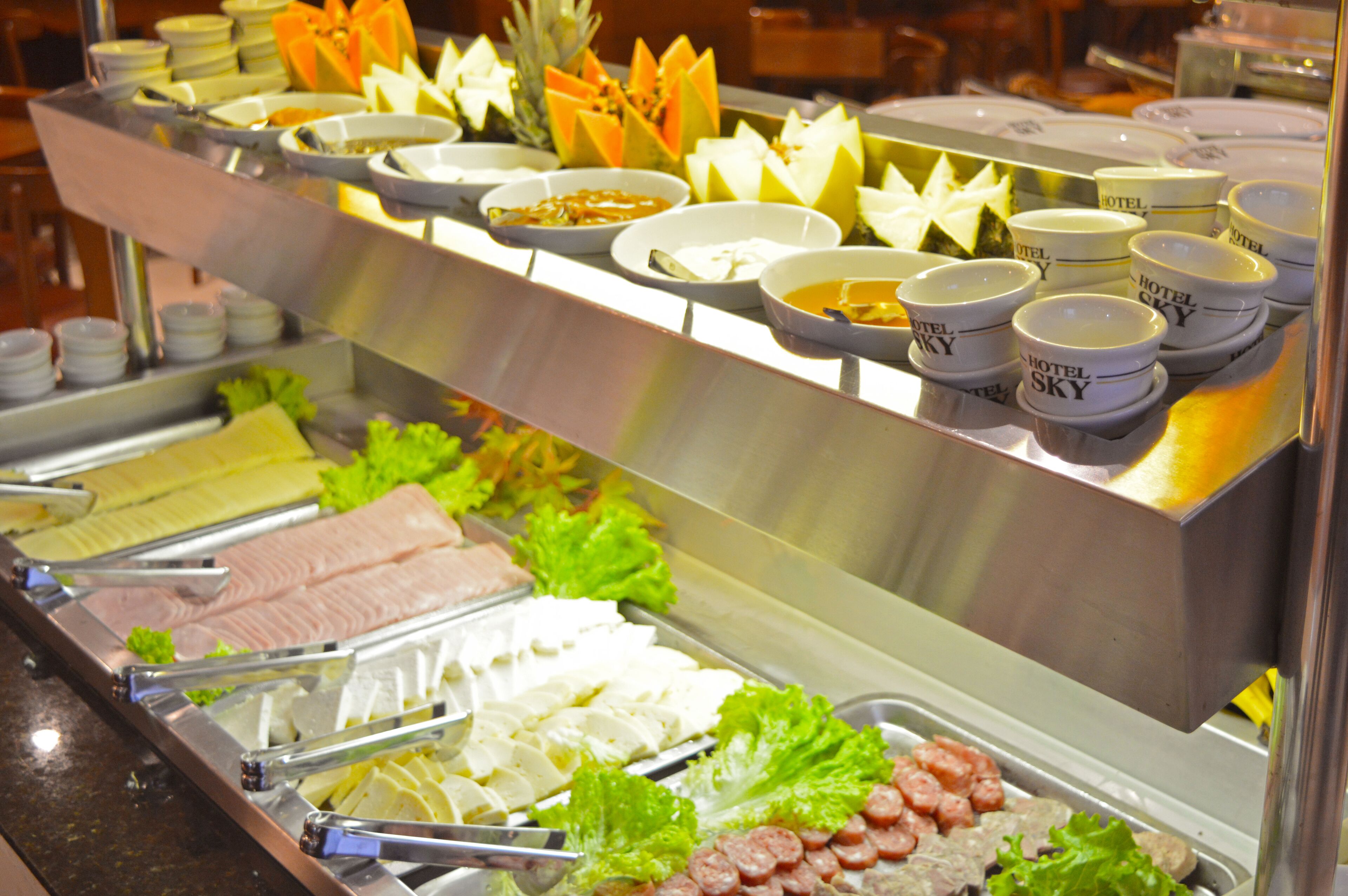 A buffet with various food items and condiments.