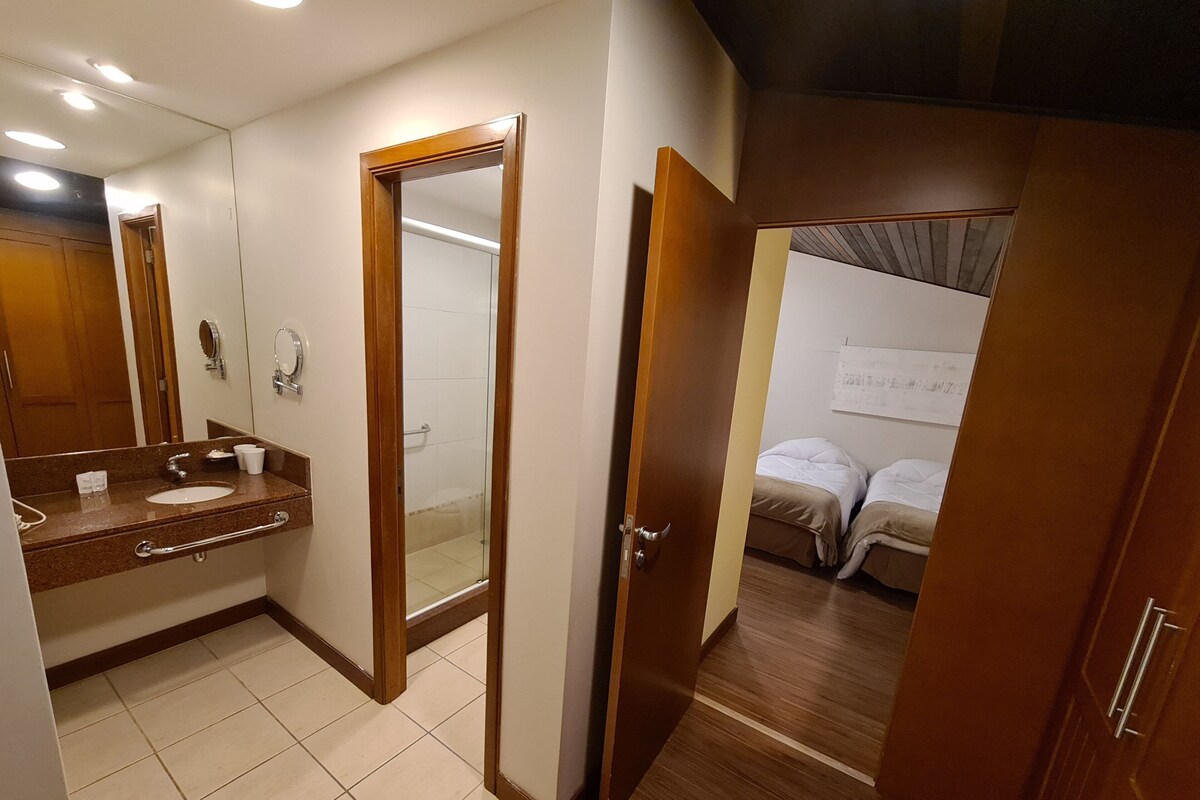 Baño con lavamanos, espejo y ducha.