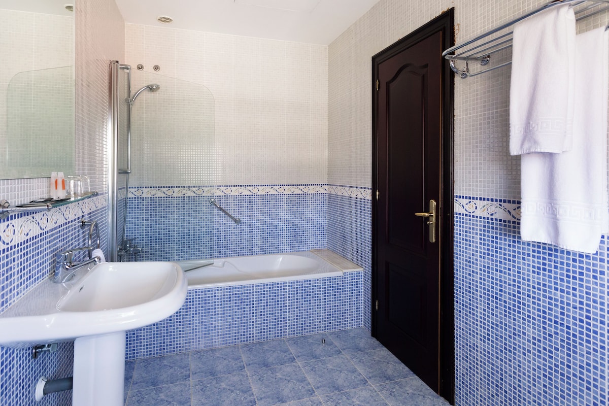 Un baño con bañera, lavabo y ducha.