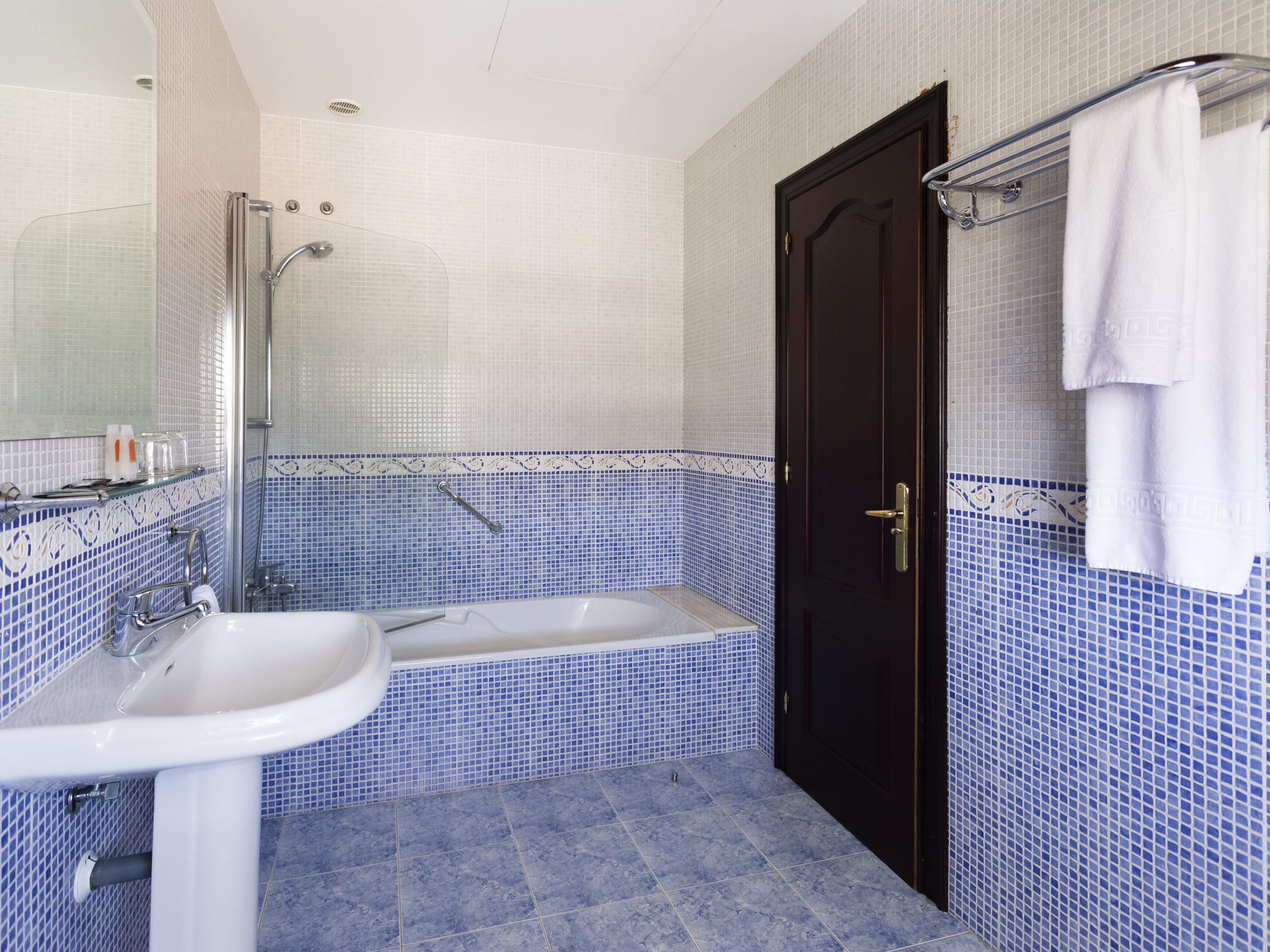 Een badkamer met een bad, een wastafel en een douche.