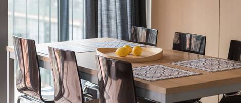 A dining table with a laptop, two lemons, and a plate.