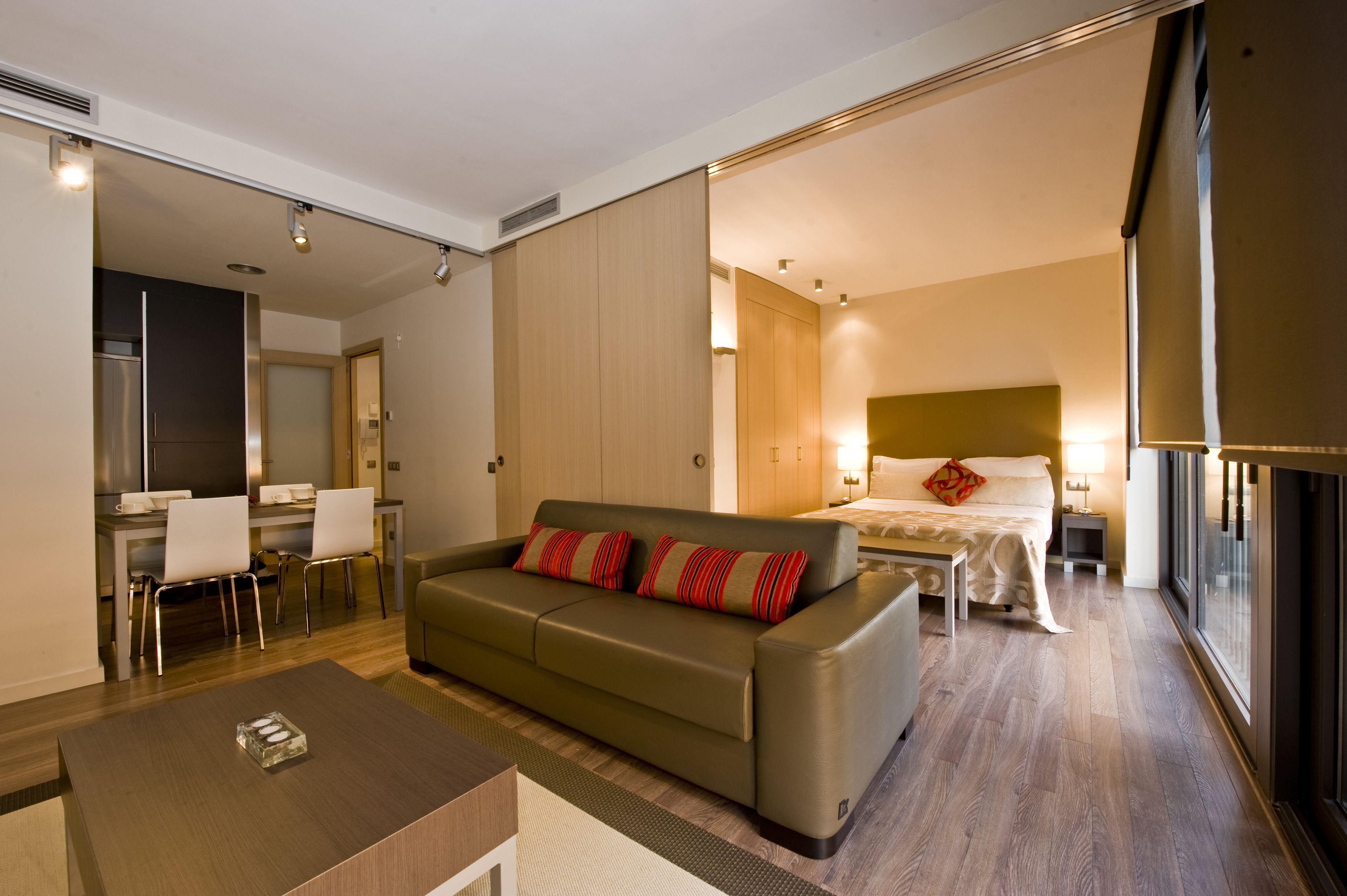 Et moderne hotelværelse med sofa, spiseplads og separat soveværelse.