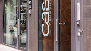 Un edificio moderno con grandes ventanales y un cartel que dice 'CASP74 Apartments'.