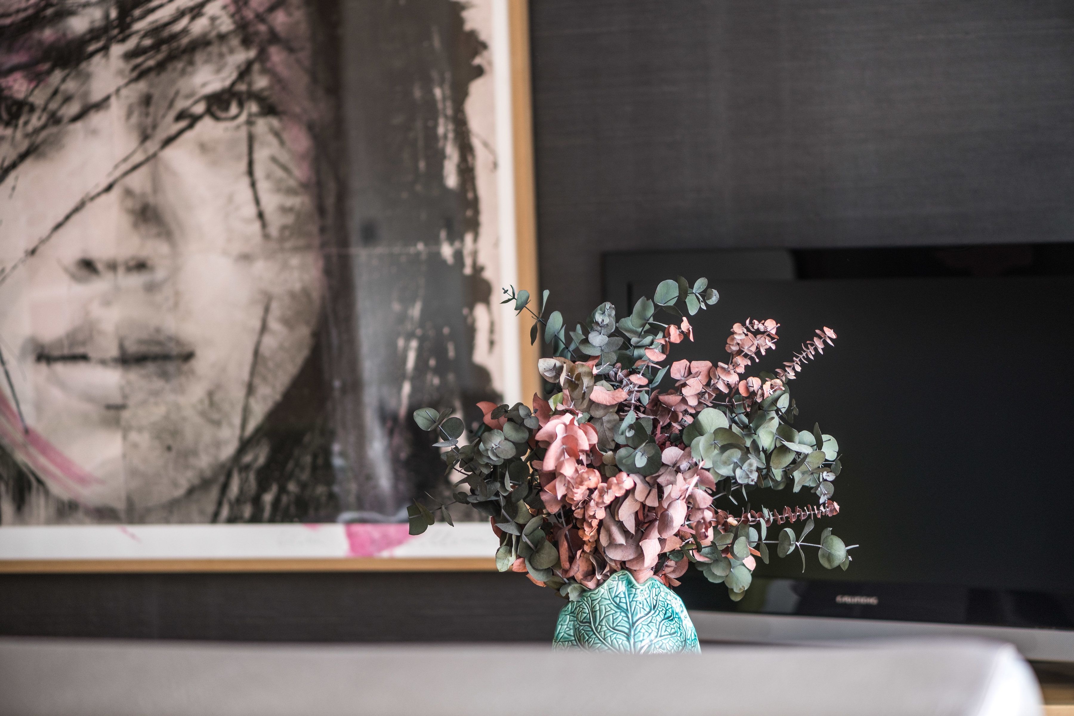 Un jarrón con flores sobre una mesa.