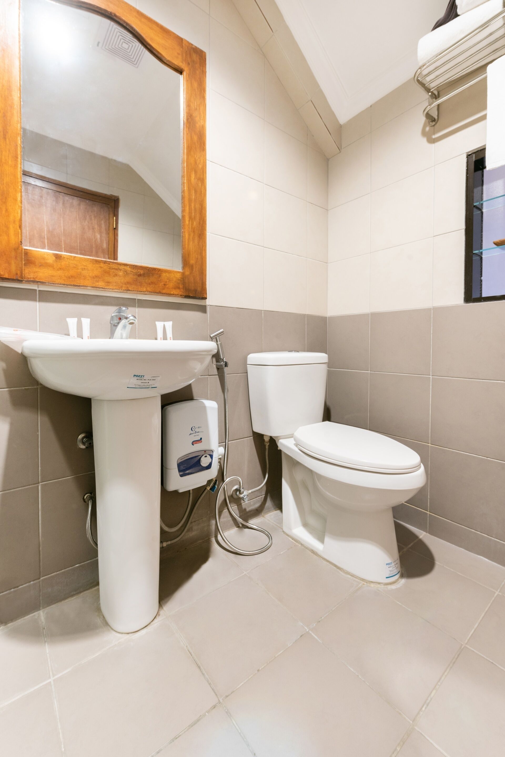 A bathroom with a white sink, a mirror, a toilet, and a hand dryer.