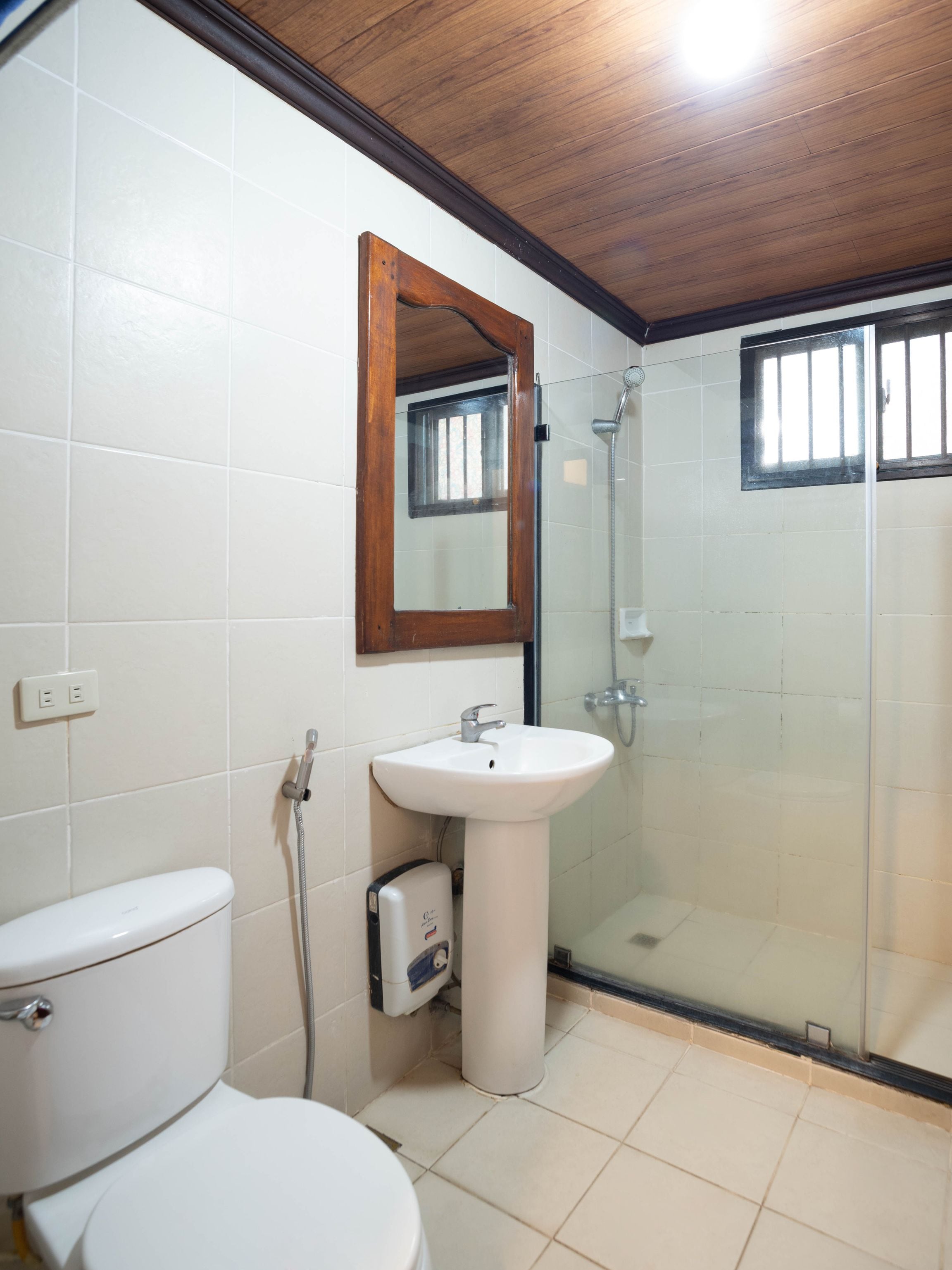 A bathroom with a toilet, a sink, and a glass-enclosed shower.