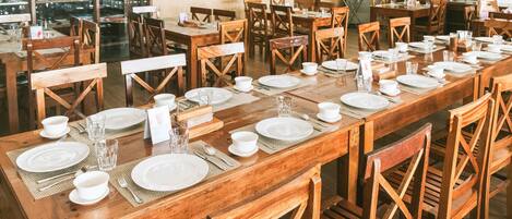 Un restaurant avec des tables et des chaises en bois, disposées pour accueillir les clients.