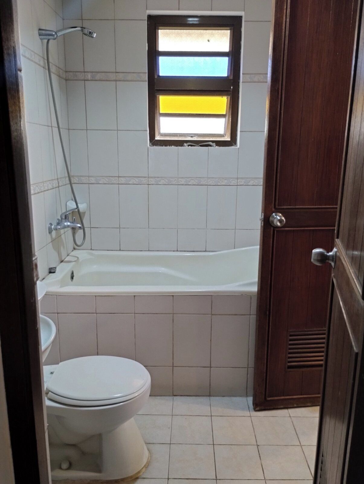 Une salle de bain avec une baignoire, des toilettes et une fenêtre donnant sur le ciel.