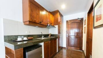 A kitchen with wooden cabinets, a stainless steel sink, and a dishwasher.