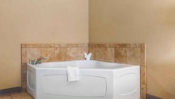 A corner bathroom with a freestanding bathtub, a towel rack, and a sink.