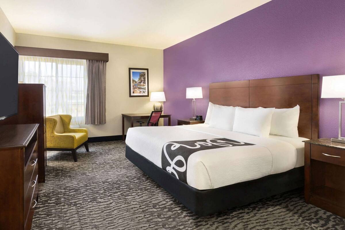 Une chambre d’hôtel équipée d’un lit, d’un bureau, d’une chaise et d’un téléviseur.