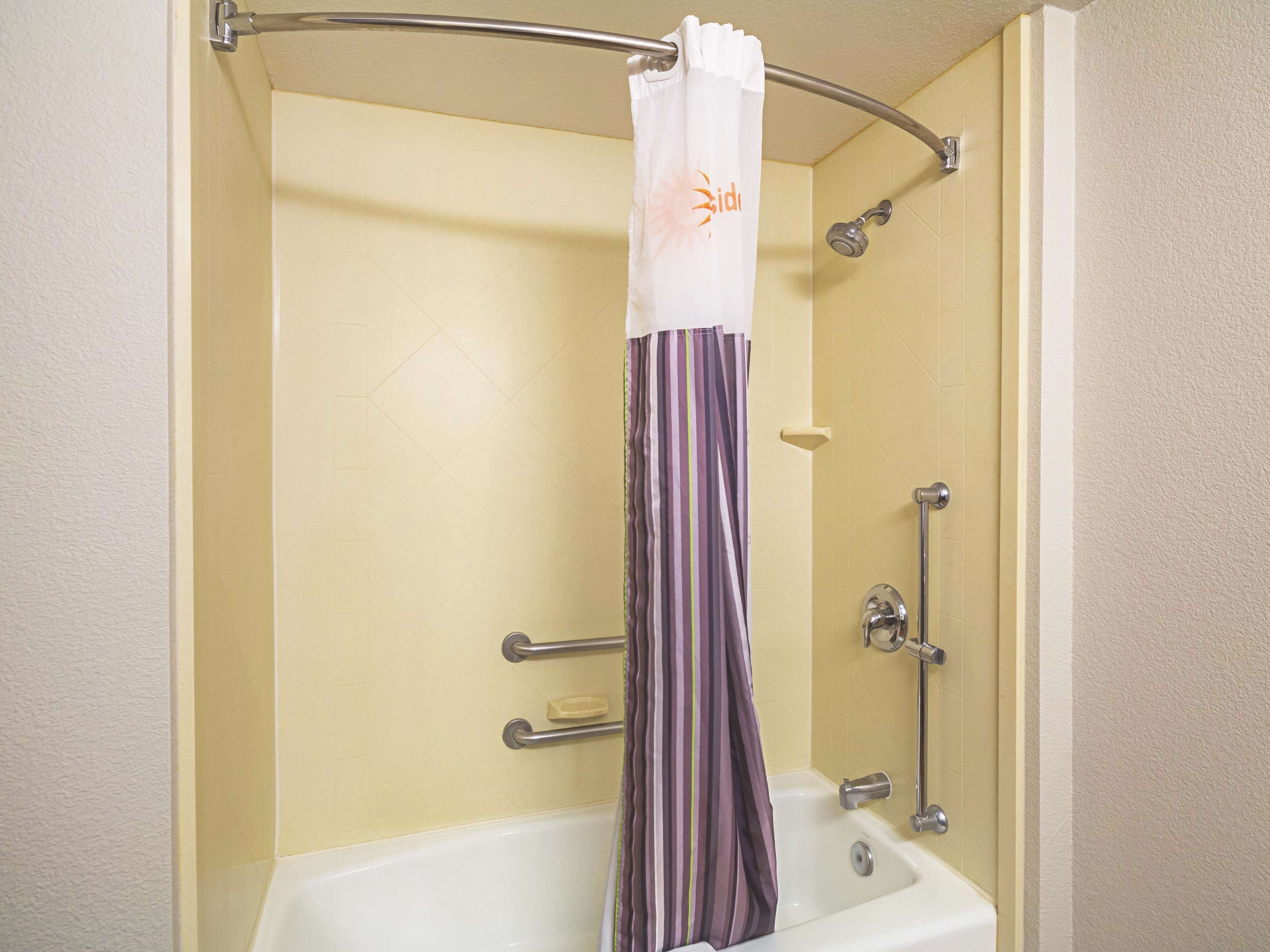 A bathroom with a bathtub, a shower, and a curtain.