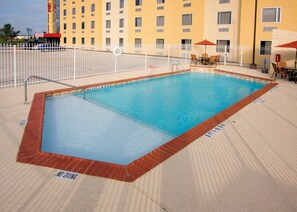 A rectangular pool with a white fence, a lifebuoy, and a 'NO DIVING' sign. - Red Roof Inn & Suites Beaumont (Beaumont)
