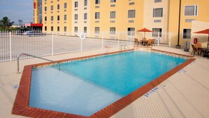 A rectangular pool with a white fence, a lifebuoy, and a 'NO DIVING' sign. - Red Roof Inn & Suites Beaumont (Beaumont)