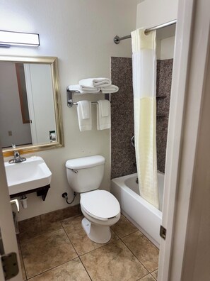 A bathroom with a toilet, sink, and bathtub. - Blue Bonnet Suites Extended Stay Lubbock, Texas (Lubbock)