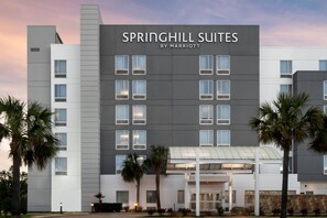 A modern hotel building with a sign reading "SPRINGHILL SUITES BY MARRIOTT".