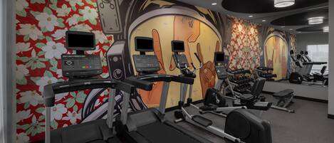 Un gimnasio con cintas de correr, elípticas y estaciones de pesas.
