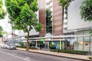 Un edificio moderno con fachada de vidrio, una entrada cubierta y un letrero que dice 'Hotel de Ville'.