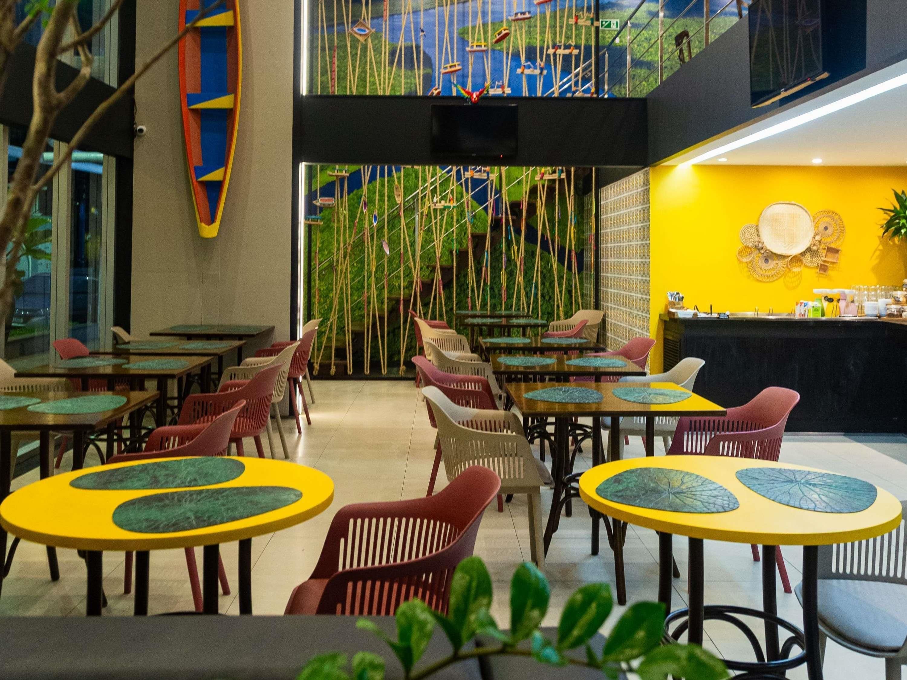 Un restaurante con varias mesas y sillas, una zona de bar y vistas a un puente.