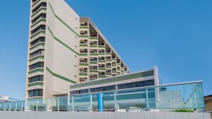 Ein modernes Gebäude mit einem unverwechselbaren, winkelförmigen Design, das mehrere Balkone und eine Glasfassade aufweist.