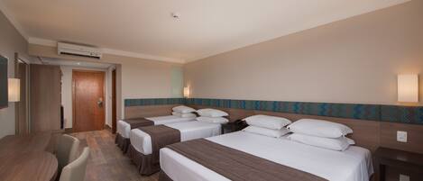A hotel room with two beds, a desk, and a chair.