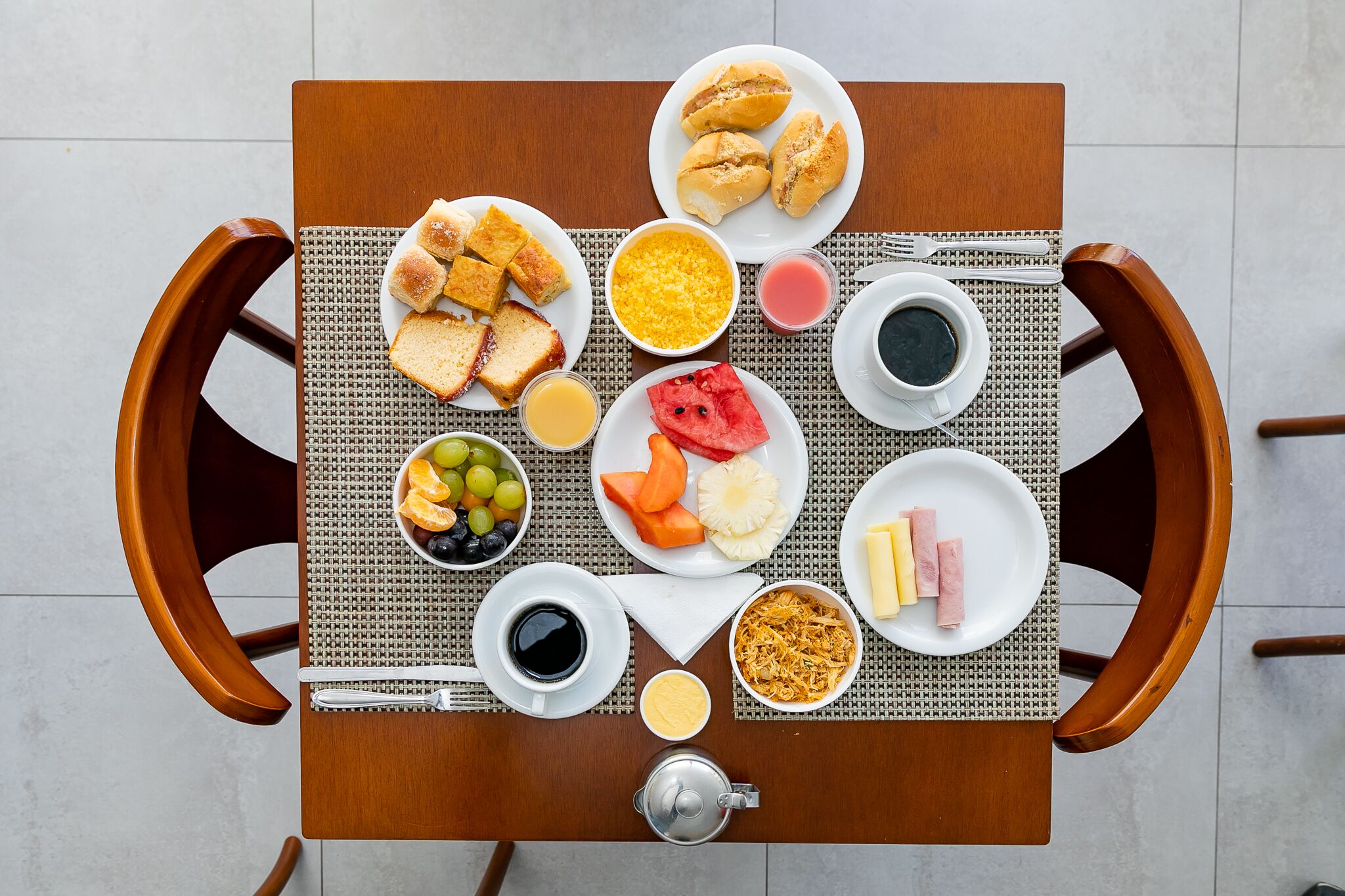 A breakfast table with various food items and beverages.