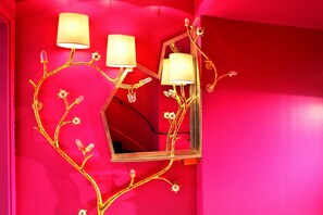 A bathroom with a mirror, three wall-mounted lamps, and a red wall. - Cristal Champs Elysees (Paris)