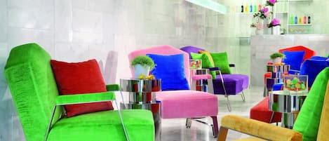 A modern lobby with colorful chairs and a glass coffee table.