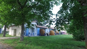 Gebäude mit blauen Dächern, Außenbereichen zum Sitzen und einem Rasen.
